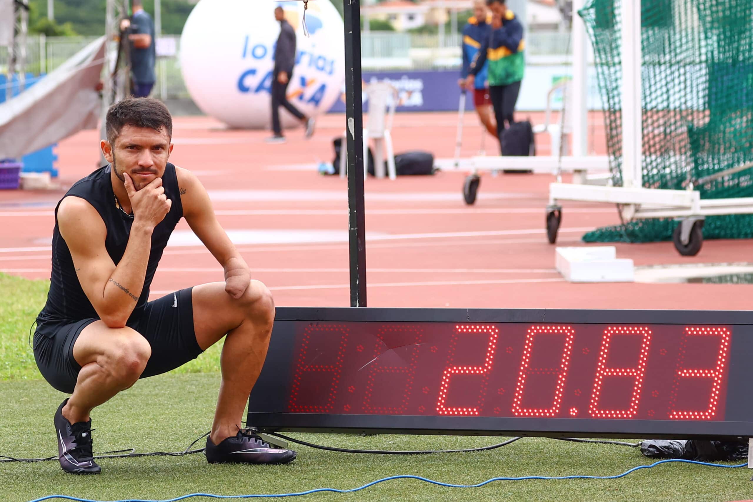 Petrúcio ferreira está ajoelhado ao lado do placar com o tempo de 20s83