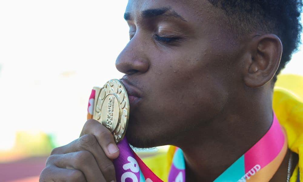 Ronicleiton Santos beija sua medalha de ouro no lançamento de disco do atletismo. Rosário 2022 Time Brasil