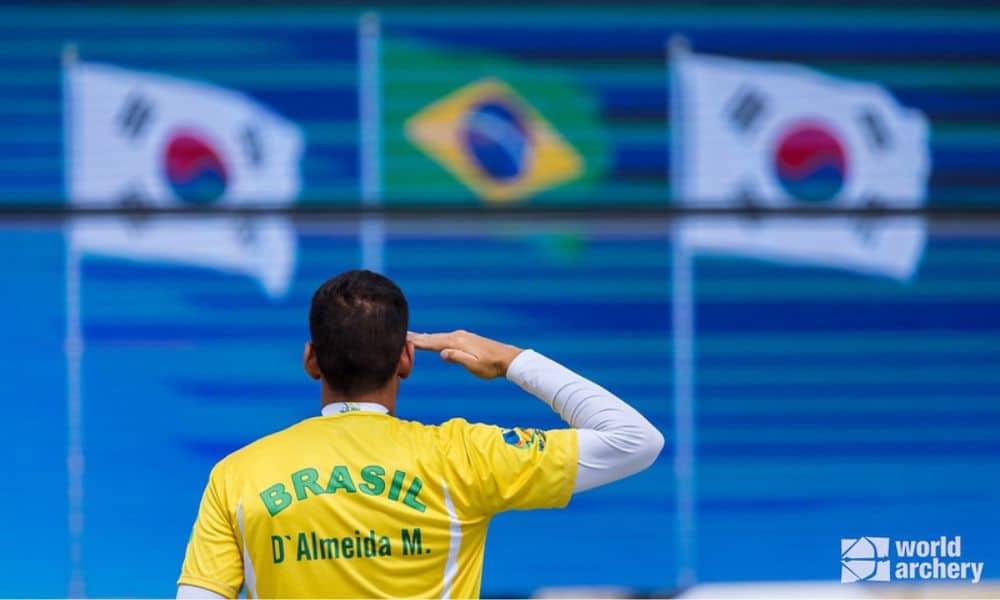 MArcus D'Almeida bandeira do Brasil no lugar mais alto do pódio na Copa do Mundo de Paris de tiro com arco