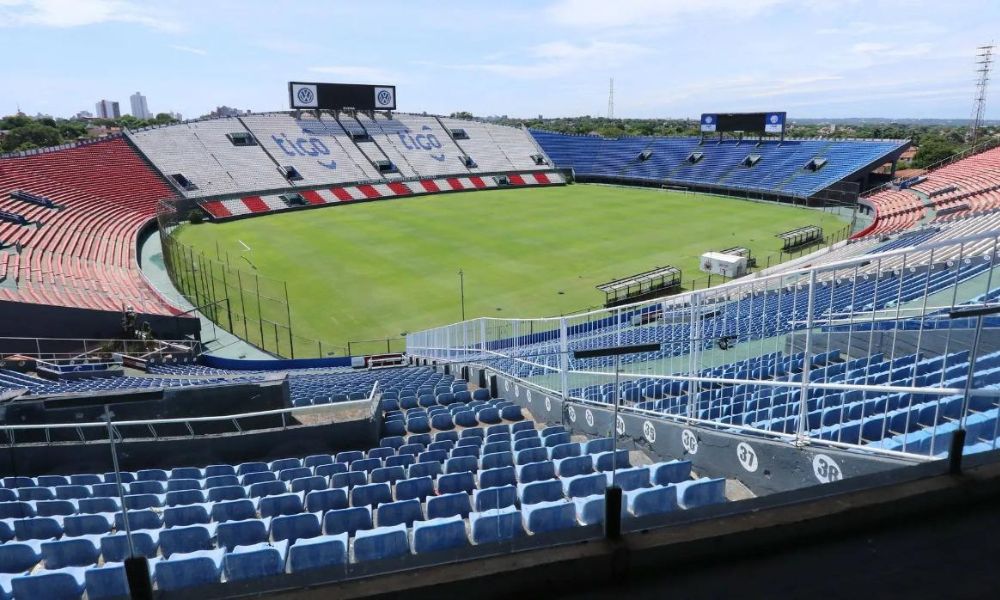 Panorama do Estádio da Abertura de Assunção-2022, com arquibancadas em vermelho, branco e azul.