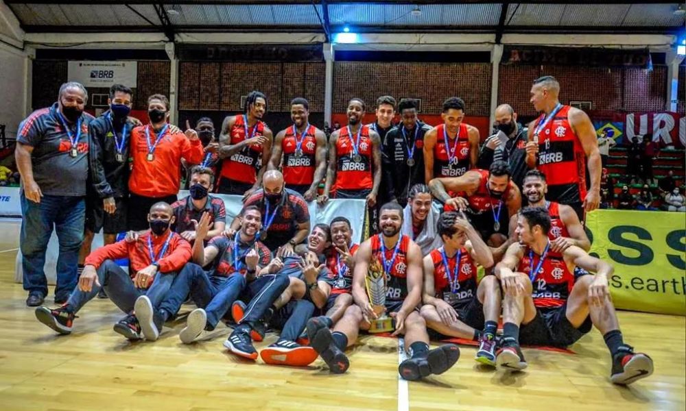 Jogadores do Flamengo posam para foto com medalhas e o troféu do Carioca de basquete
