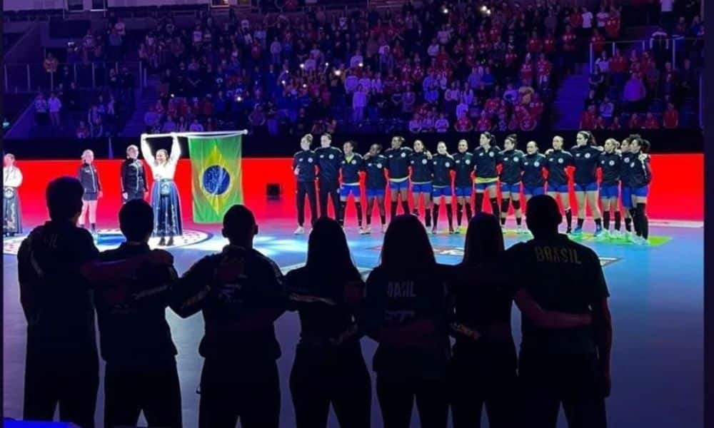 Equipe do Brasil, antes do jogo com a Dinamarca, enfileiradas para o hino nacional. Na frente da image, a comissão técnica de costas
