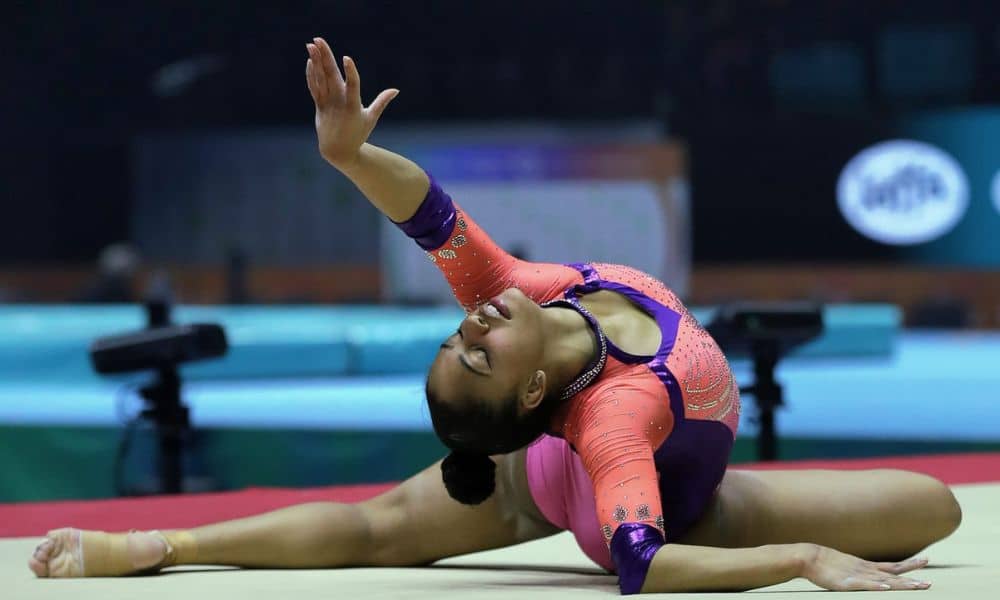 Carolyne Pedro deitada no solo durante sua coreografia. Ela irá competir no Pan-Americano de ginástica