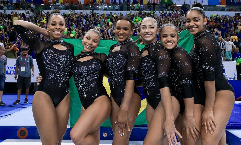 Brasil - Mundial: Lorrane, Flávia, Rebeca, Júlia, Christal e Carol posam para foto. Ao fundo, elas seguram uma bandeira do Brasil