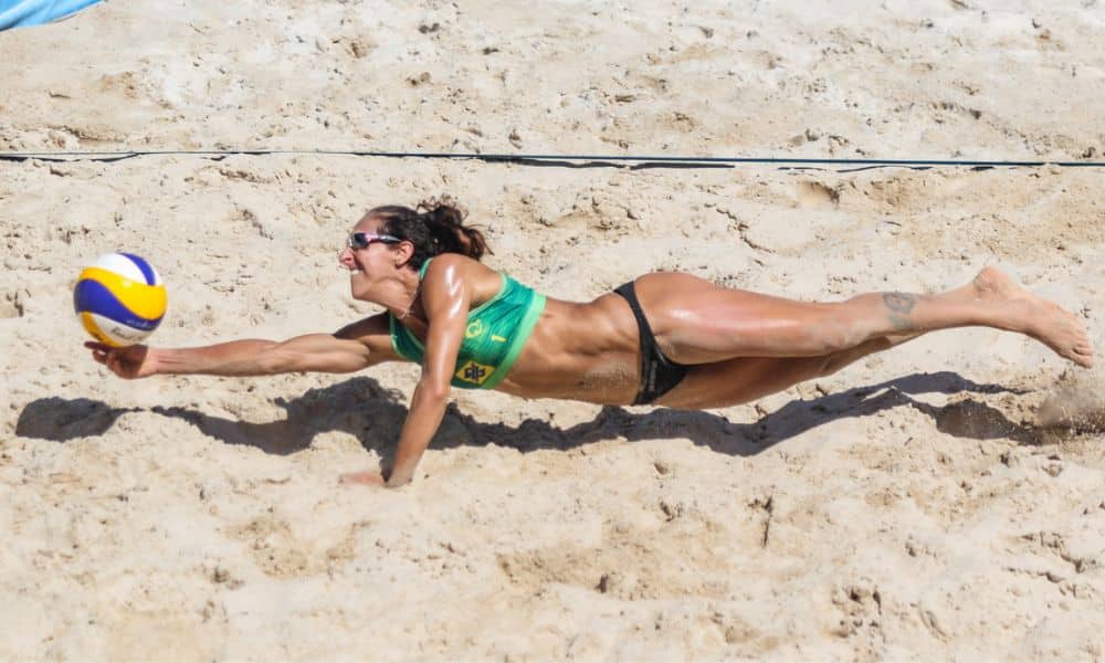 Aberto de Maceió: Josi Alves se apoia com um braço na areia e se estica para salvar uma bola