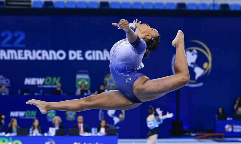 Mundial de ginástica artística. Rebeca Andrade faz um salto anel: pernas esticadas, com o pé de trás subindo na altura da cabeça da ginasta