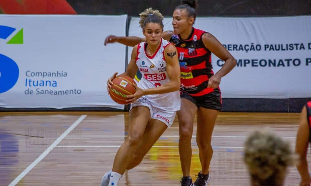 Sesi Araraquara x Ituano: Sossô, usando uniforme branco, carrega a bola cercada por atleta do Ituano, vestindo uniforme rubro-negro