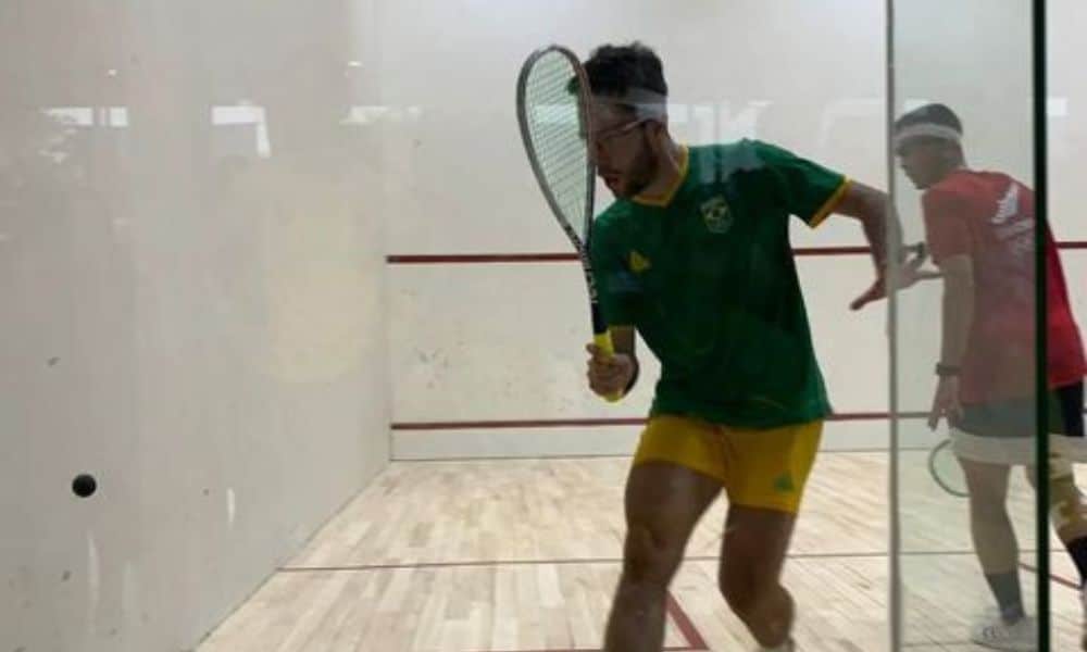 Brasil - Diego Gobbi, usando shorts amarelo e camiseta verde, corre para rebater a bola squash jogos sul-americanos