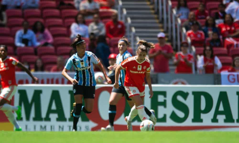 Gauchão Feminino: Jogadora do Internacional recebe a bola e atleta do Grêmio pressiona na marcação