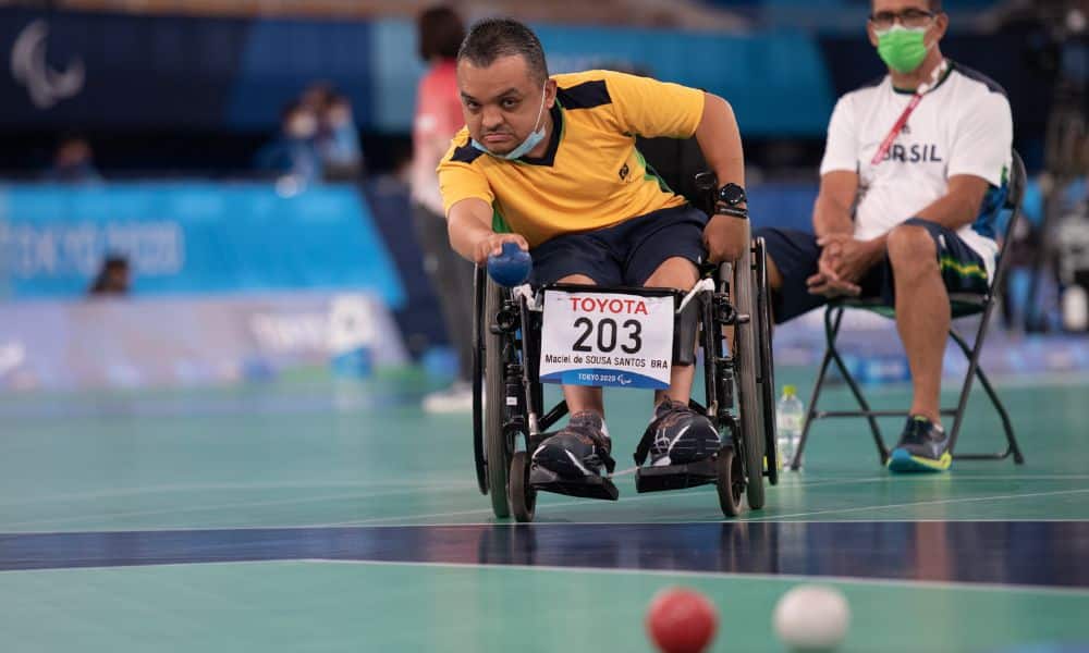 Mundial de bocha: Maciel Santos em sua cadeira joga uma bola azul em direção ao bolim