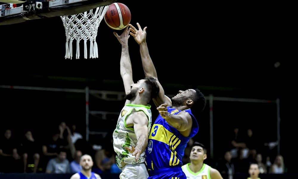 Bauru Basket x Boca Juniors - jogador do Bauru tenta cesta de bandeja. Jogador do boca atrás dele tenta um toco