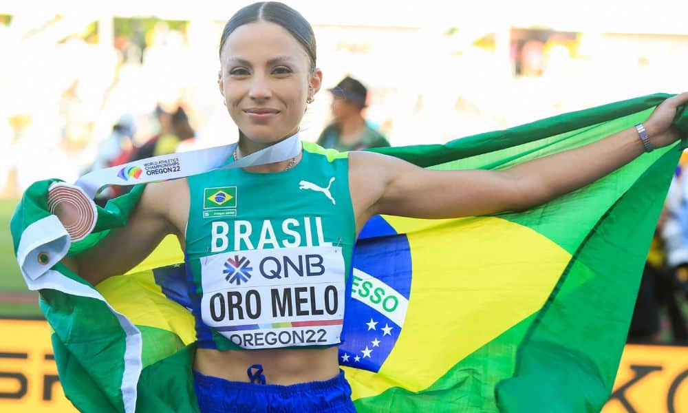 Letícia Oro Melo segura a medalha e uma bandeira do brasil