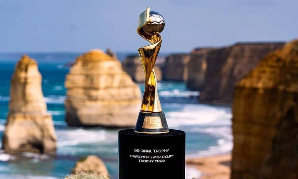 Troféu da Copa do Mundo Feminina de futebol com uma praia ao fundo