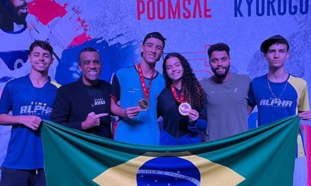 No centro da imagem, Adriano dos Santos e Melyssa Resende seguram medalhas do Aberto Dominicano Júnior de taekwondo