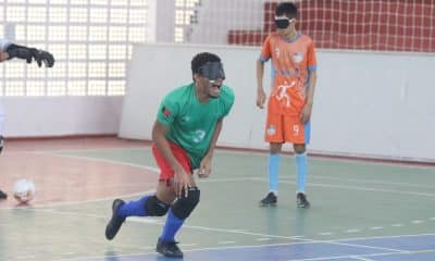 Maicon está se levantando do chão da quadra após comemorar seu gol. Ele grita enquanto apoia o corpo no joelho direito. Veste camiseta verde, calção vermelho e meiões azuis da Apace (Renan Cacioli/CBDV)