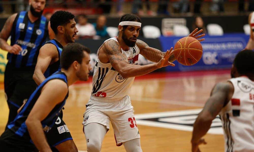 Jogador do São Paulo enquanto passa a bola no jogo contra o Pinheiros no NBB