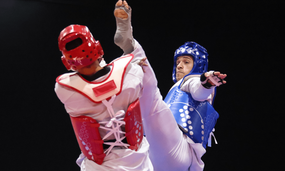 Ícaro Miguel chutando adversário na cabeça no Mundial de taekwondo. Ele e Camila Bezerra foram longe, enquanto Lucas Ostapiv perdeu uma fase antes