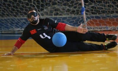 Atleta do IRM faz defesa no Regional Sul de goalball. Ele veste um uniforme todo preto, com detalhes em vermelho. A bola é azul