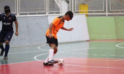 Raynã conduz a bola, com um marcador mais afastado à esquerda da imagem. Atleta veste camisa laranja com detalhes em preto, da Acelgo, calção preto e meiões brancos (Renan Cacioli/CBDV)