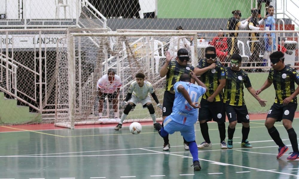 Selmi, da ADVP, chuta de pé esquerdo, a bola vai passando pelo lado da barreira com três atletas da Uniace e, ao fundo, o goleiro Igor aguarda a trajetória da bola com os olhos bem atentos ao lance (Renan Cacioli/CBDV)