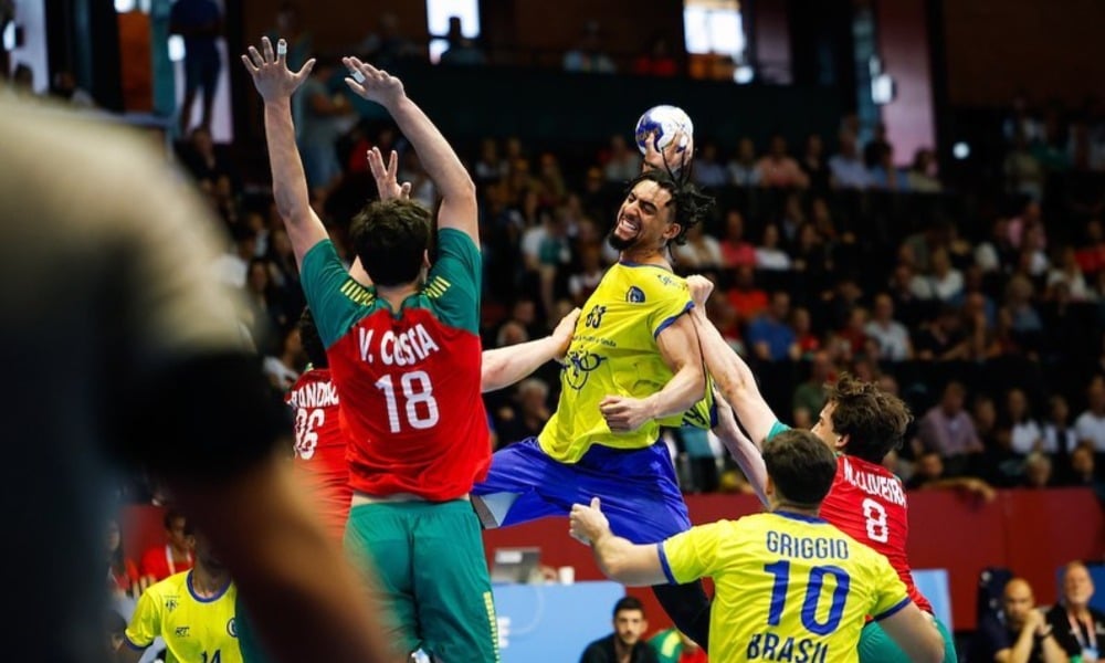 Hugo Monta, do Brasil, tenta finalizar enquanto é atrapalho por portugueses no Mundial Júnior de Handebol masculino