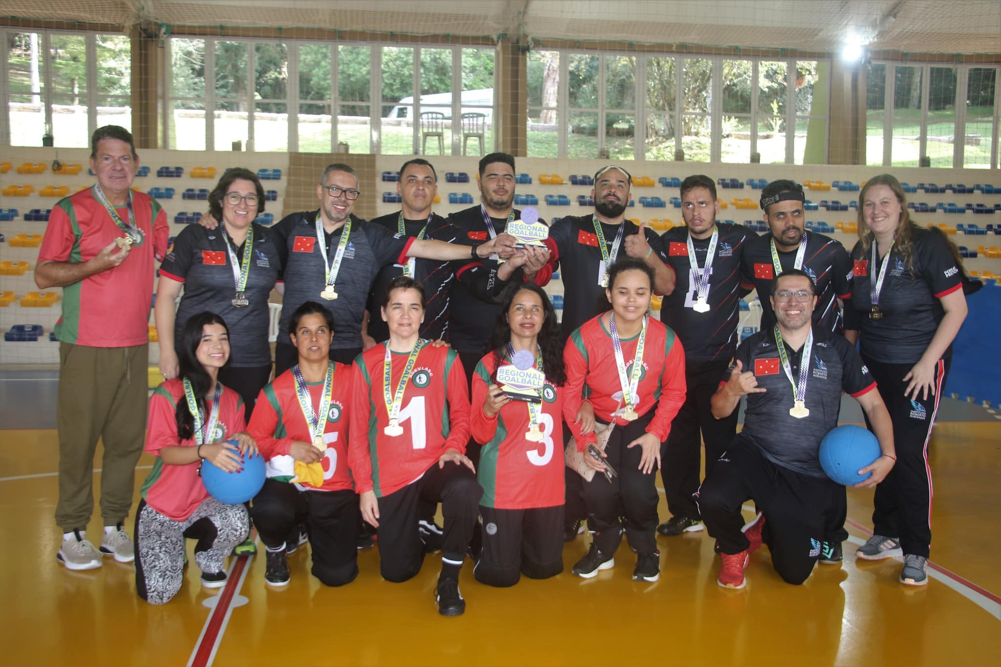Na imagem, equipes do IRM e da Adevlasc posam na quadra com as medalhas de ouro e os troféus dos respectivos título no masculino e feminino do Regional Sul.