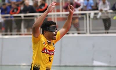 Na imagem, Leandro Moreno ergue os braços na comemoração de seu gol. Ele veste camisa amarela com detalhes em preto da Uniace.
