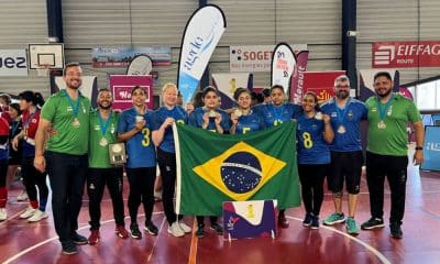 Atletas e comissão técnica da seleção feminina de goalball do Brasil posam para foto com as medalhas de ouro