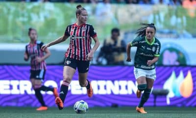Jogadora do São Paulo conduz a bola marcada por atleta do Palmeiras. Times fazem clássico no Paulistão Feminino ao vivo