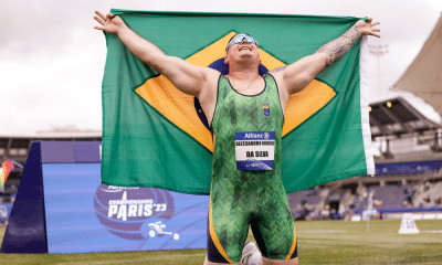 Alessandro Rodrigo da Silva ajoelhado e com a bandeira do Brasil após mais um título no Mundial de atletismo paralímpico