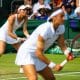 Luisa Stefani e Caroline Garcia agachadas para receber saque no Torneio de Wimbledon