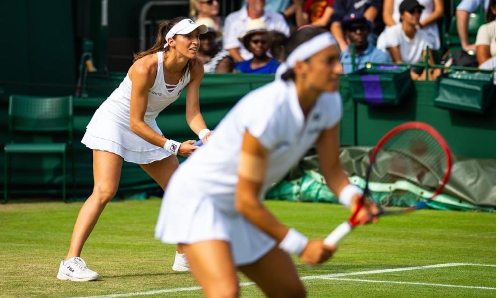 Luisa Stefani e Caroline Garcia agachadas para receber saque no Torneio de Wimbledon