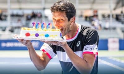 Na imagem, Marcelo Melo mordendo o bolo de comemoração à sua milésima partida no circuito da ATP.