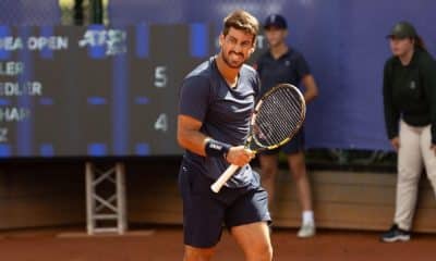Orlando Luz veste roupas azuis e comemora ponto com a mão direita segurando a raquete