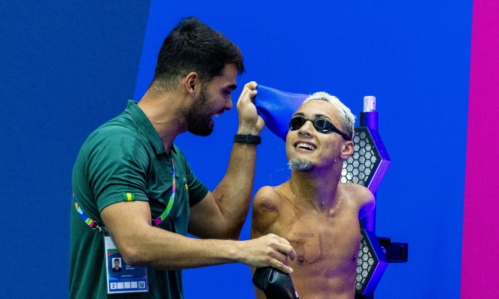 Samuel Oliveira e seu treinador vibram com medalha de ouro dos 50m borboleta da classe S5