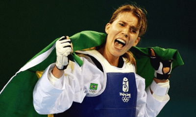 Natália Falavigna carrega uma bandeira do Brasil e comemora o bronze no taekwondo em Pequim-2008