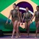 Na imagem, time brasileiro de ginástica rítmica com a bandeira do Brasil ao fundo.