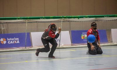 Há dois jogadores do IRM, com uniforme vermelho e preto. Um está destacado e faz o movimento de arremesso, enquanto o outro aparece ao fundo, ajoelhado. (Foto: Taba Benedicto/CBDV)