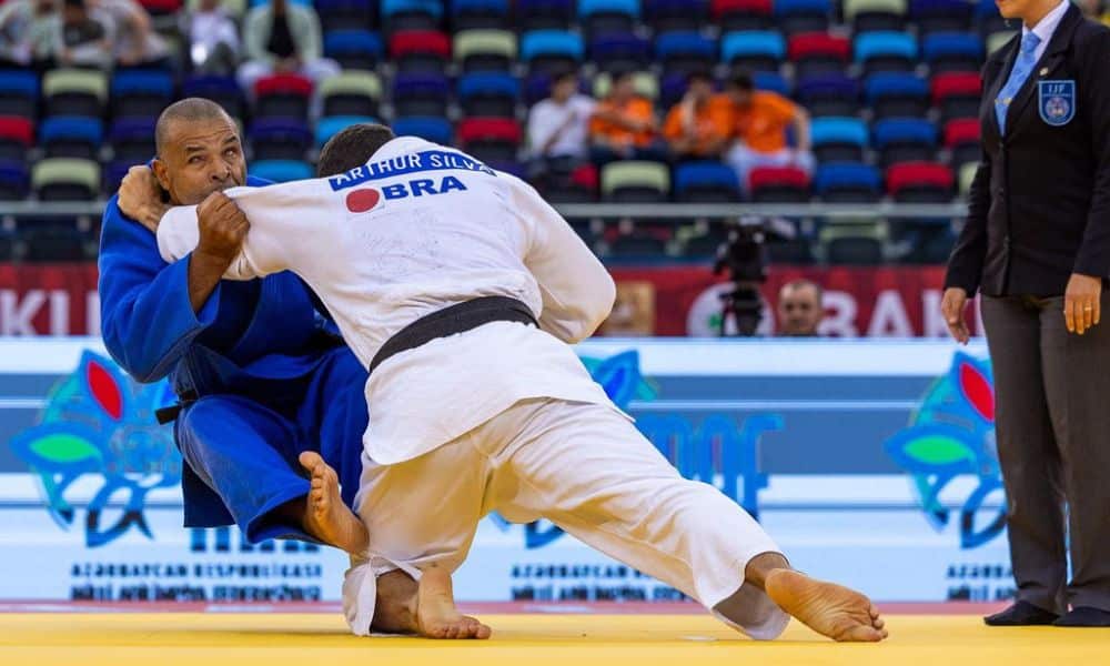 Arthur, que está de costas e veste quimono branco, derruba Tenório, que usa quimono azul e aparece de frente para a imagem no Grand Prix de Baku de judô paralímpico (Foto: Divulgação/CBDV)