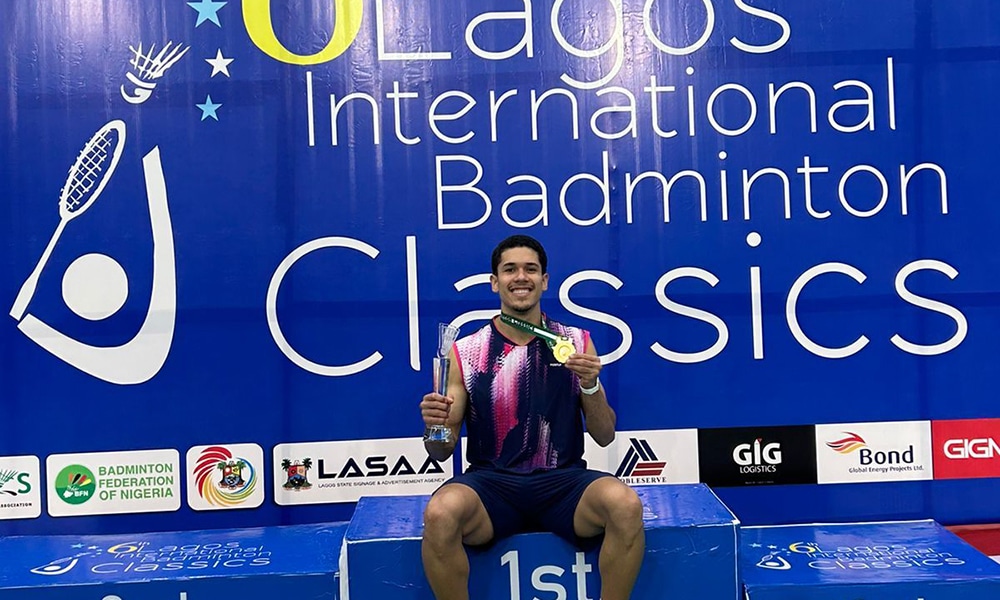Na imagem, Jonathan Matias sentado no lugar mais alto do pódio com sua medalha.