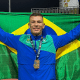 Vinícius de Brito posa para foto com a bandeira do Brasil