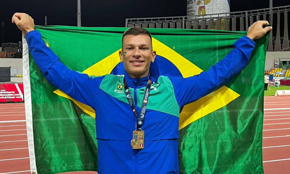 Vinícius de Brito posa para foto com a bandeira do Brasil
