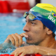Breno Correia, de touca verde e amarela, está na piscina, de lado, e olha para frente no s Jogos Pan-Americanos de Santiago-2023