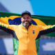 Claudiney Batista com a bandeira do Brasil após medalha de ouro no lançamento de disco no Parapan de Santiago-2023
