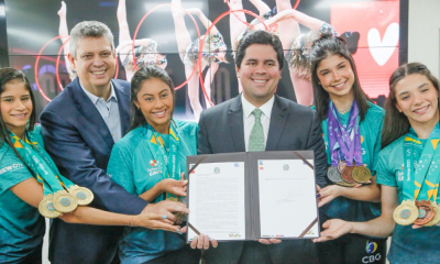 Atletas brasileiras e ministro André Fufuca com placa de candidatura para o Mundial de ginástica rítmica de 2025