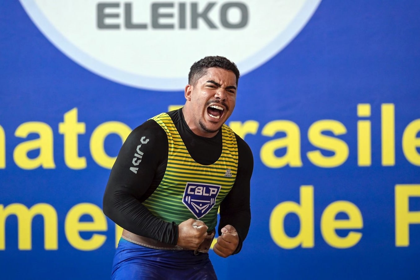 Na imagem, Pedro Greco vibrando após quebrar recorde de levantamento.