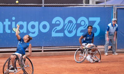Maria Fernanda Alves joga a bola no ar para sacar. Meirycoll Duval observa no fundo. Partida da final dos Jogos Parapan-Americanos