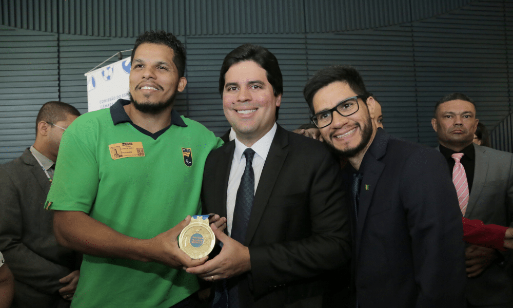 André Fufuca, ministro do Esporte, segura medalha de ouro dos Jogos Parapan-Americanos ao lado de Leomon MOreno, atleta de goalball, e do ex-atleta Yohansson Nascimento; ele anunciou reajustes no Bolsa Atleta para paralímpicos