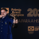 Marcus D'Almeida faz pose de tiro com arco segurando o Troféu Rei Pelé no Prêmio Brasil Olímpico