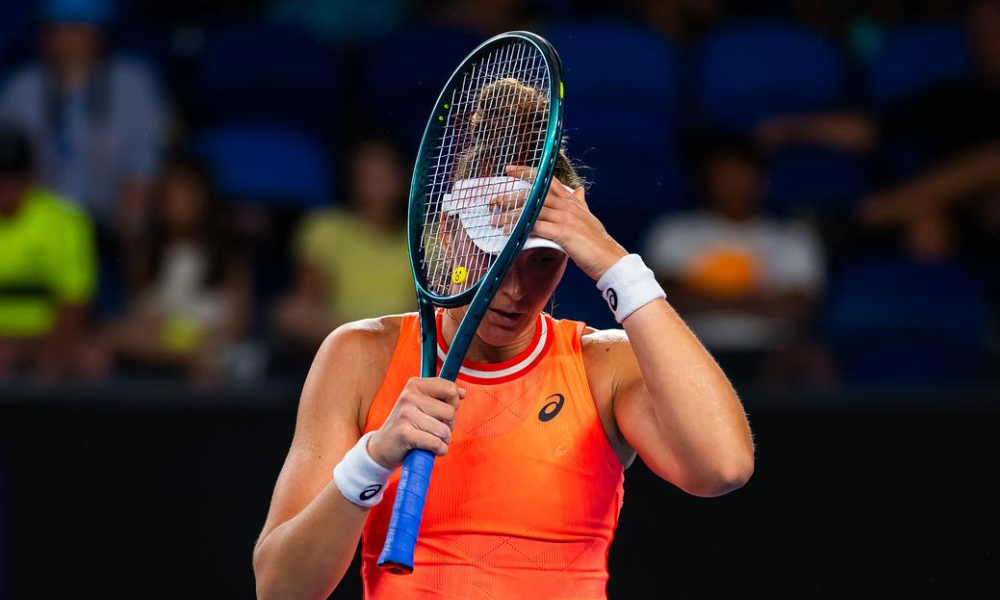 Bia Haddad, de laranja, com as mãos na cabeça em lamentação após derrota para Timofeeva no Australian Open